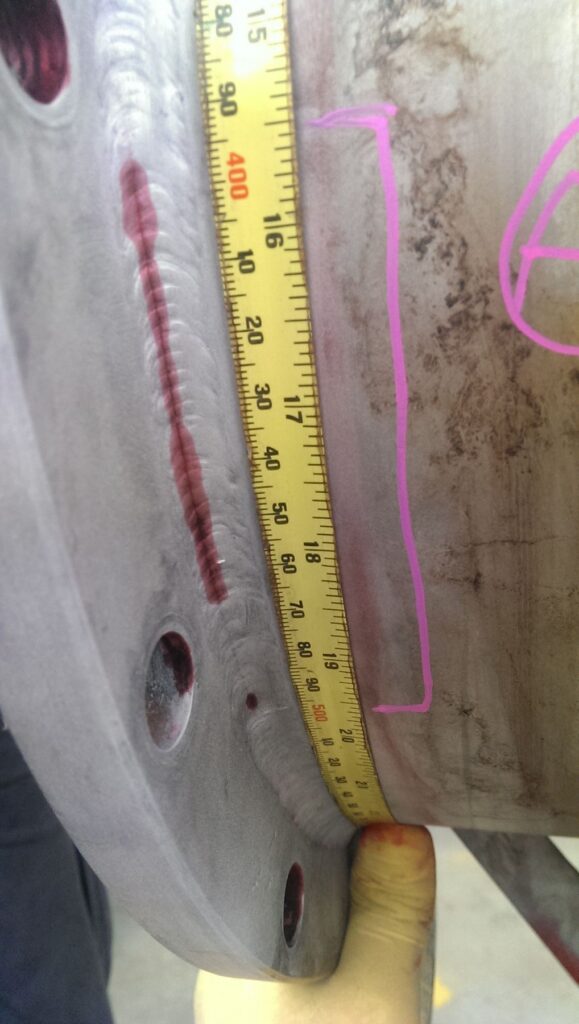 Dye penetrant indication on a flange weld, measured with a tape