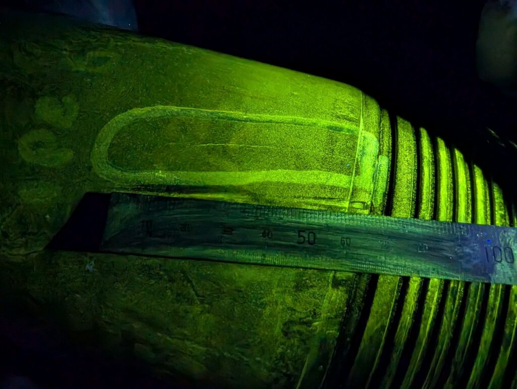 Fluorescent magnetic particle inspection revealing a crack indication